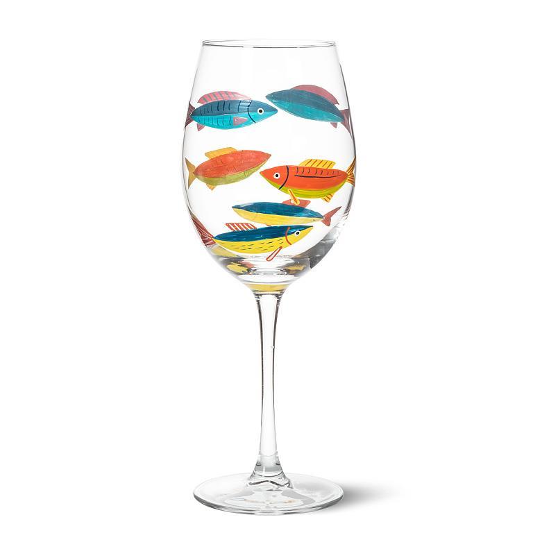 Verre à vin à pied transparent orné d'illustrations peintes de poissons multicolores dans des nuances de bleu, d'orange et de jaune.