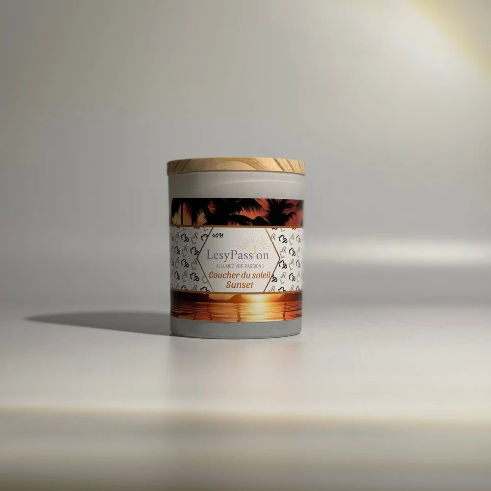 Bougie parfumée format moyen (40 h) en pot cylindrique gris clair avec couvercle en bois clair, arborant l'étiquette « Coucher du soleil / Sunset » de la marque LesyPassion sur fond studio épuré.