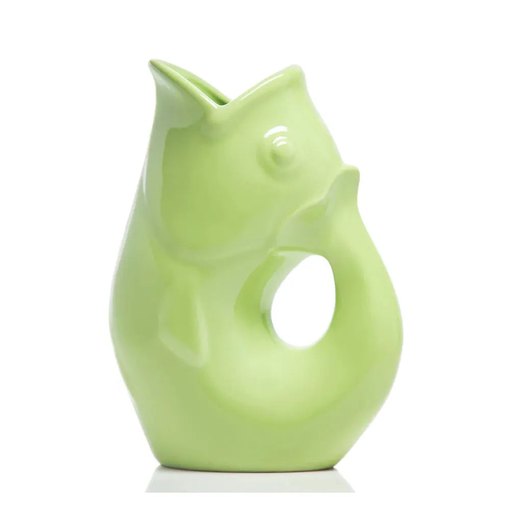 Carafe décorative (Gurgle Pot) en céramique émaillée de couleur vert pâle, sculptée en forme de poisson dressé dont la gueule ouverte sert de bec verseur et le corps courbé forme l'anse.
