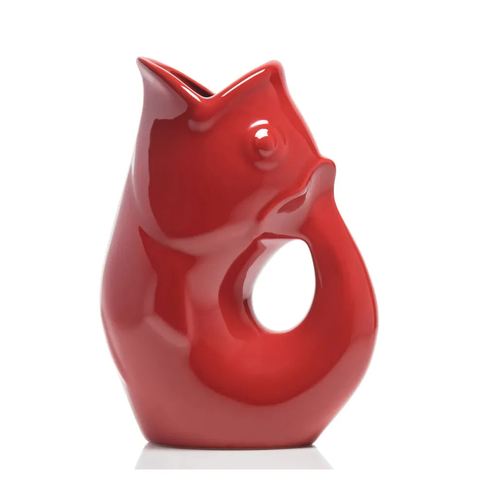 Carafe décorative (Gurgle Pot) en céramique émaillée de couleur rouge, sculptée en forme de poisson dressé dont la gueule ouverte sert de bec verseur et le corps courbé forme l'anse.