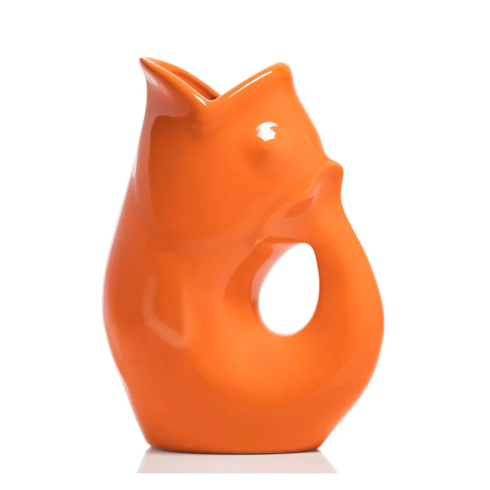 Carafe décorative (Gurgle Pot) en céramique émaillée de couleur tangerine, sculptée en forme de poisson dressé dont la gueule ouverte sert de bec verseur et le corps courbé forme l'anse.