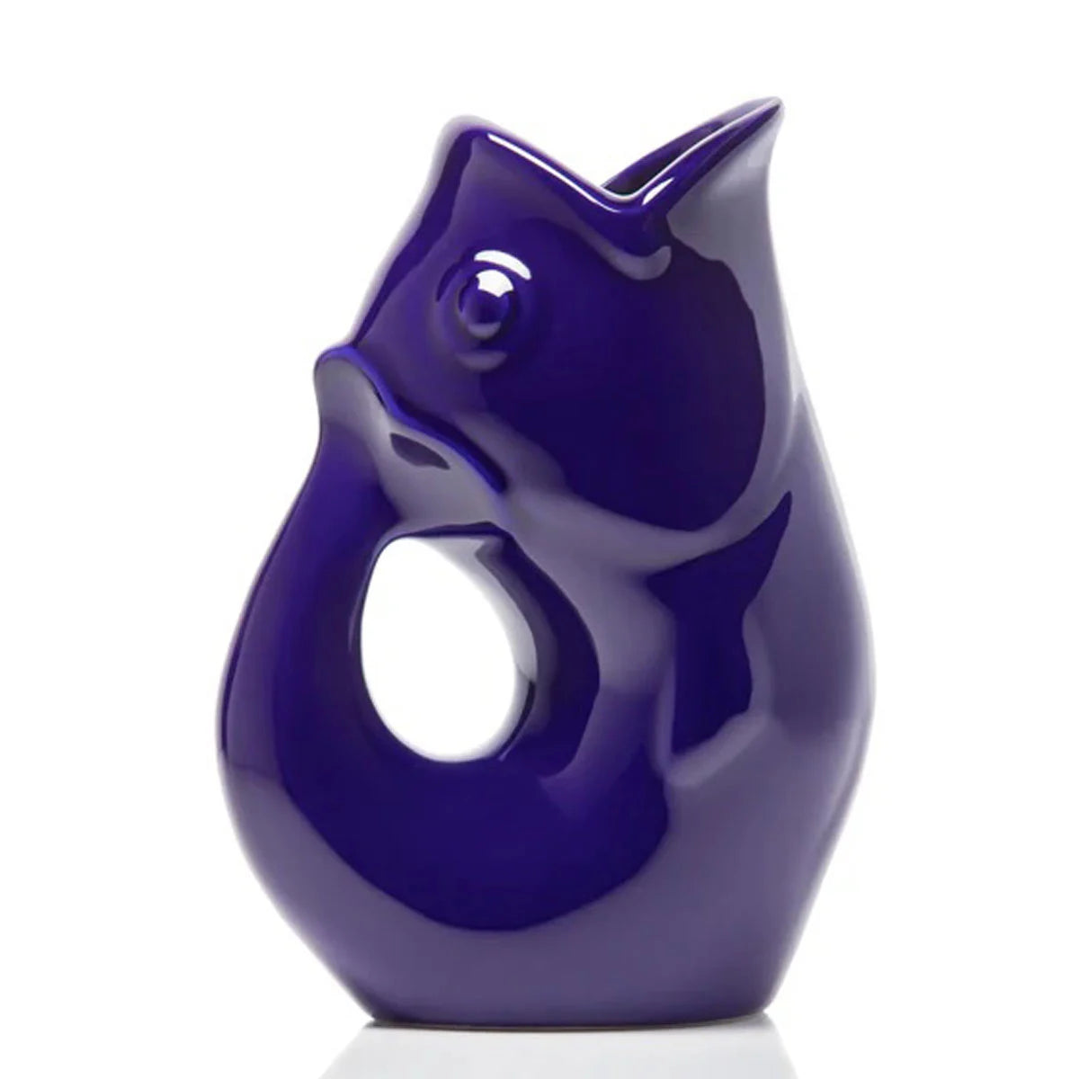 Carafe décorative (Gurgle Pot) en céramique émaillée de couleur mauve/bleu (cobalt), sculptée en forme de poisson dressé dont la gueule ouverte sert de bec verseur et le corps courbé forme l'anse.