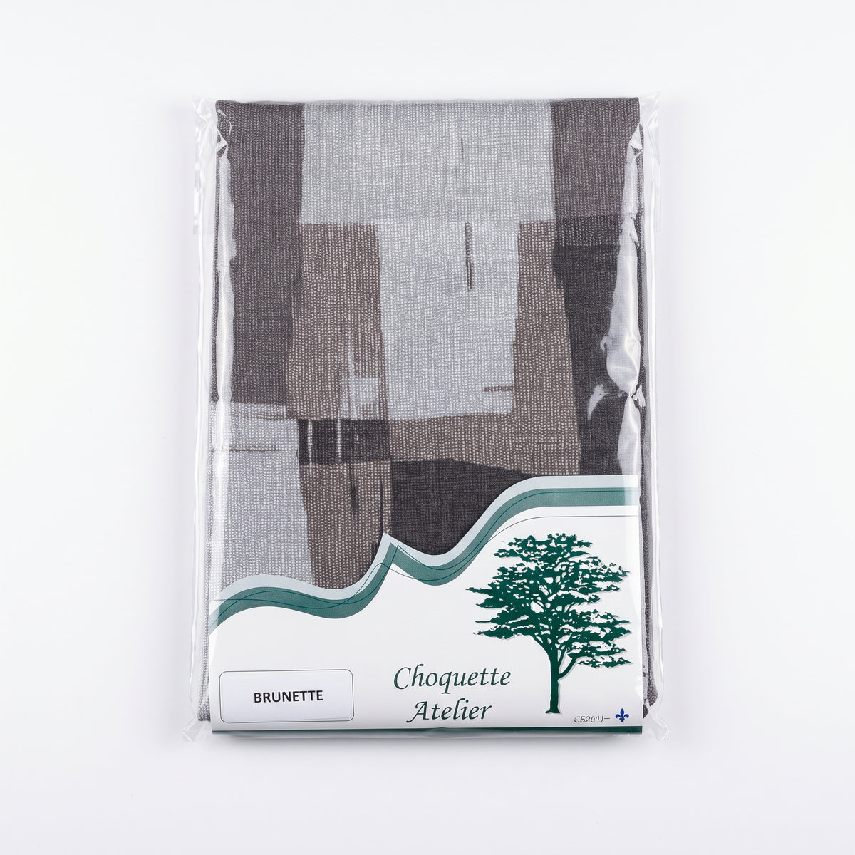 Nappe pliée sous emballage plastique, marque Choquette Atelier, modèle Brunette aux motifs géométriques abstraits dans des tons gris, taupe et anthracite.