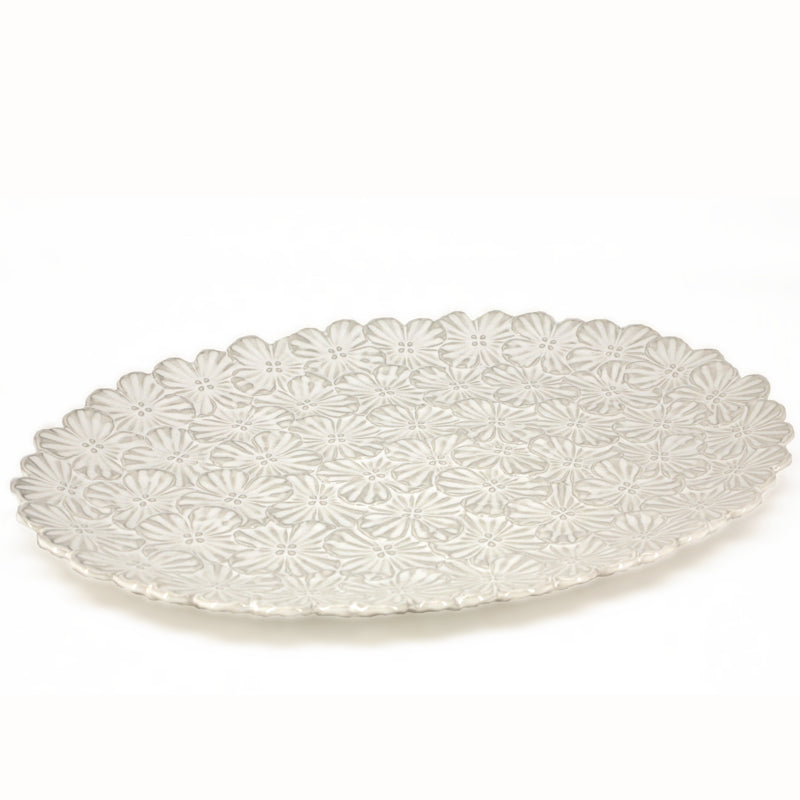 Grand plat de service rond en céramique blanc cassé orné d'un motif floral en relief et d'une bordure festonnée, bouquet de Danesco