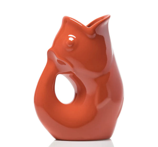 Carafe décorative (Gurgle Pot) en céramique émaillée de couleur paprika brillante, sculptée en forme de poisson dressé dont la gueule ouverte sert de bec verseur et le corps courbé forme l'anse.