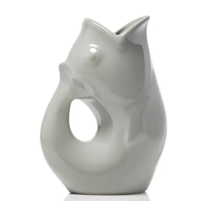 Carafe décorative (Gurgle Pot) en céramique émaillée de couleur stone, sculptée en forme de poisson dressé dont la gueule ouverte sert de bec verseur et le corps courbé forme l'anse.