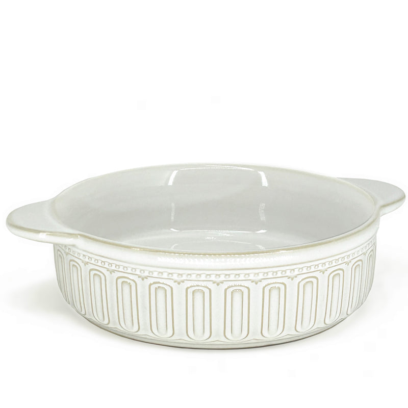 Plat de cuisson et de service rond en grès lustrée crème, muni de deux poignées plates et d'un pourtour orné de cannelures et perles en relief sur fond blanc, la peti cuisine, Danesco 